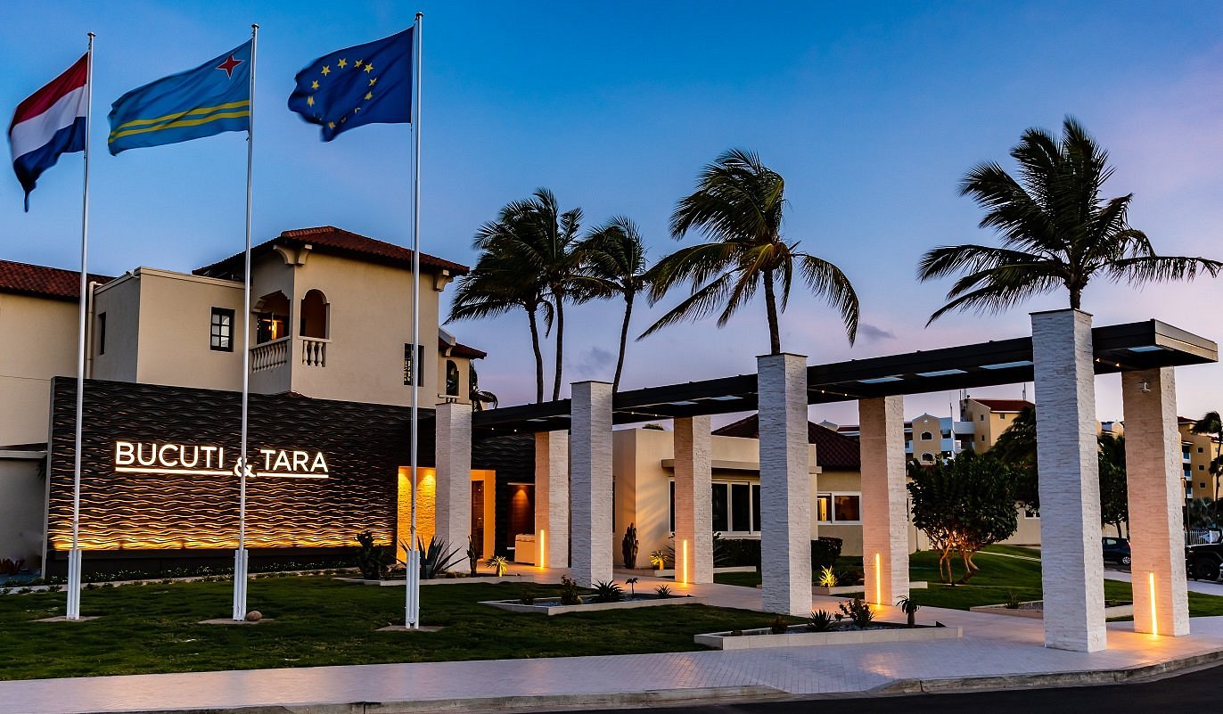 Outdoor covered entrance leading into the welcome lobby at Bucuti & Tara Beach Resort with modern architecture and palm trees.