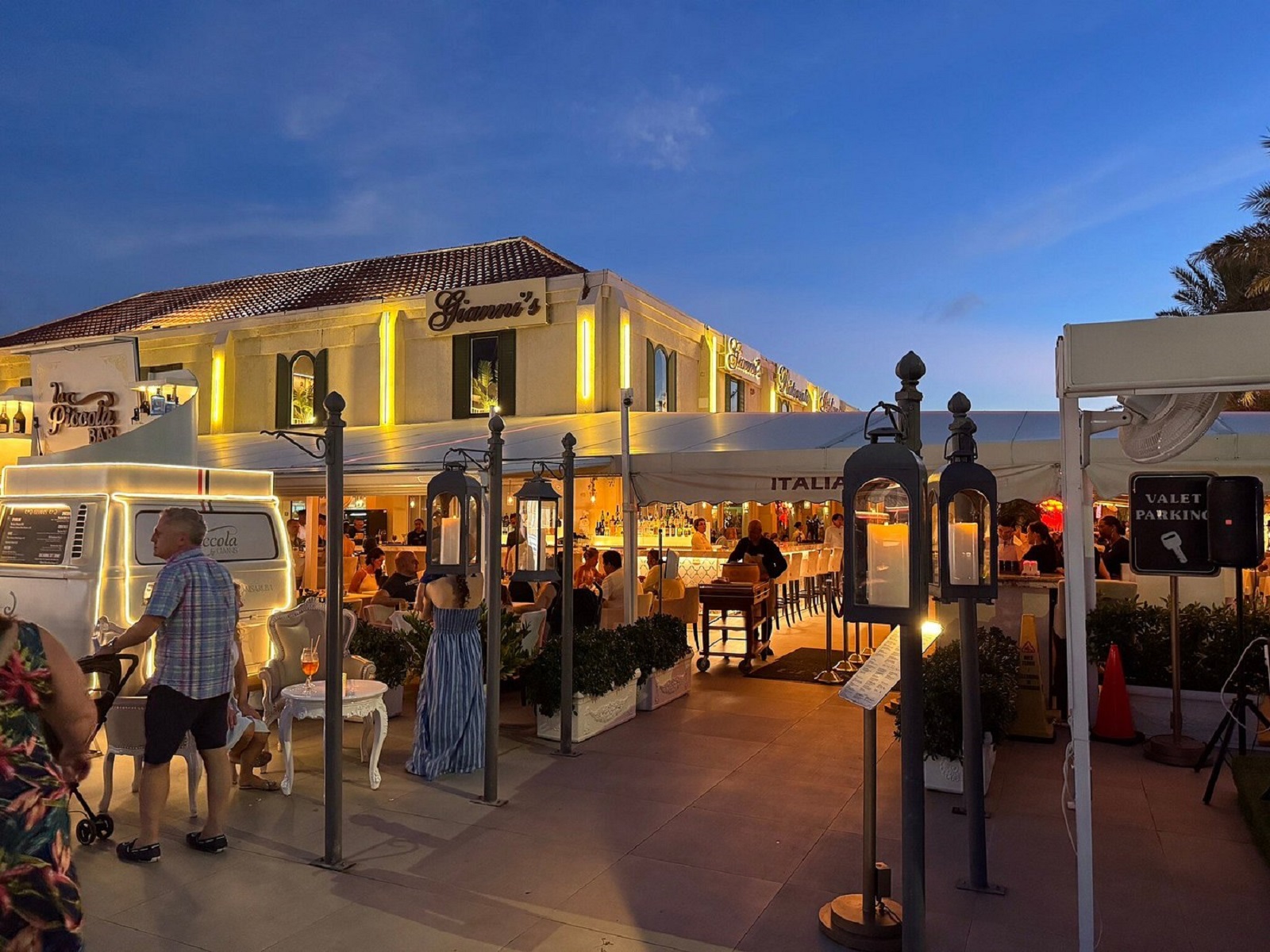 Evening entrance to Gianni's Ristorante Italiano in Aruba with outdoor seating, decorative lanterns, and illuminated signage.