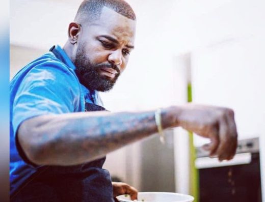 Man wearing an apron preparing food in the kitchen at Chef Life Aruba Restaurant.