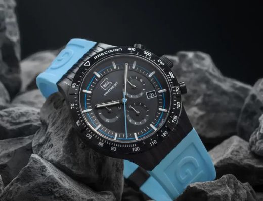 GLOCK Precision black wristwatch with a light blue strap displayed on dark rocks for Noble Jewelers in Aruba.