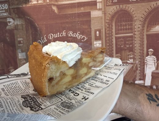 Side view of a fruit-filled pie slice with whipped cream on a plate at Old Dutch Bakery in Aruba.